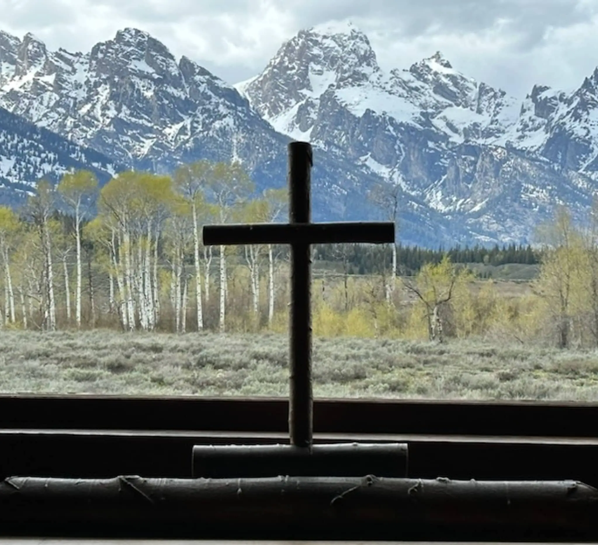 christian cross in front of mountains